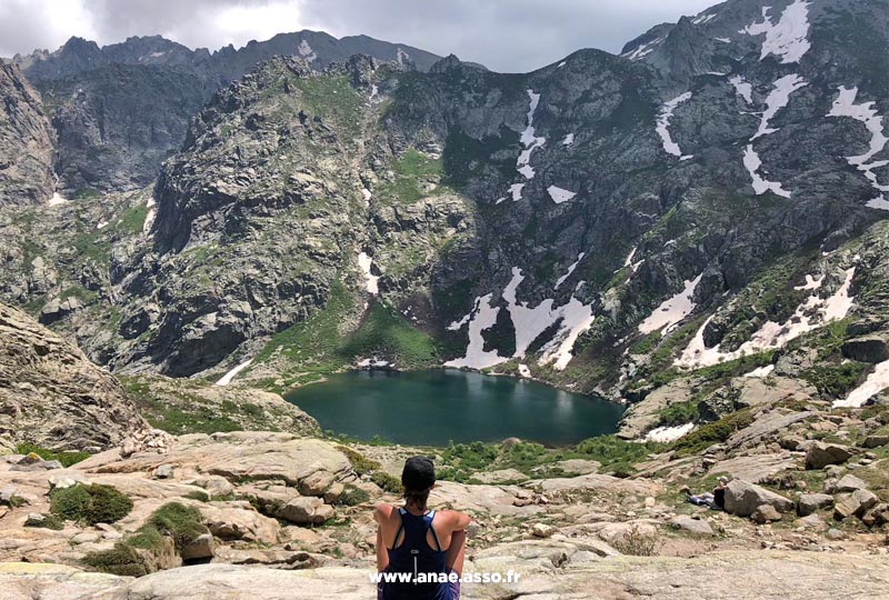 Une jeune femme en train de se ressourcer au bord d'un lac de montagne