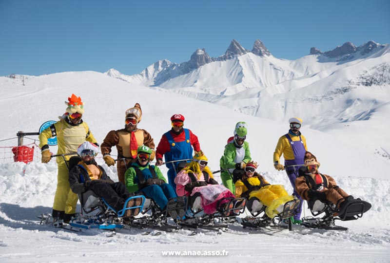 Des vacanciers et leurs accompagnateurs déguisés en personnages de Mario Bros lors d'une séance de ski assis
