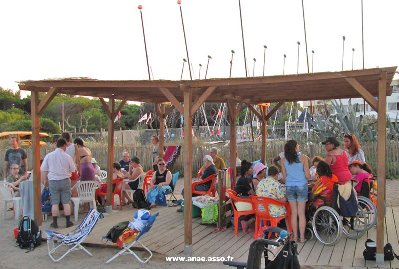 Terrasse ombragée du Pôle Handinautique de Hyères avec des vacanciers en situation de handicap