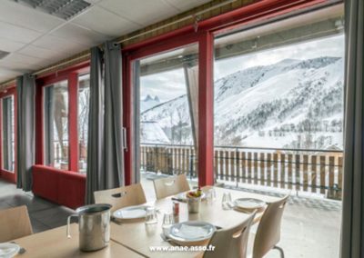 La salle à manger du centre de vacances Anaé offre une belle vue sur les montagnes enneigées