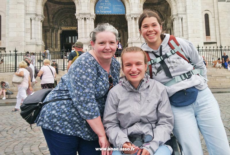 sejour-adapte-handicap-paris-montmartre-sacre-coeur Séjour adapté jeune handicap moteur à Jambville près de Paris. Une jeune femme en fauteuil roulant devant le Sacré-Coeur lors d'une visite de Montmartre.