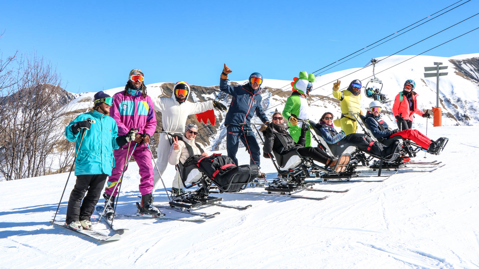 Vacanciers en situation de handicap moteur en train de faire du ski assis lors d'un séjour adapté hiver à la montagne avec Anaé vacances