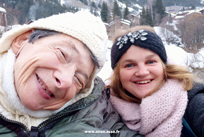 Une vacancière heureuse et son accompagnatrice lors d'un séjour adapté handicap moteur à la montagne