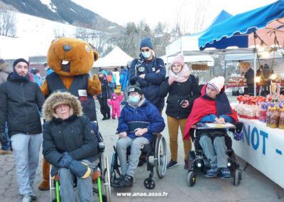 Des vacanciers en fauteuil roulant font le marché pour découvrir des produits locaux. Séjour adapté handicap moteur Anaé Vacances.