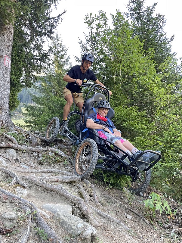Un vacancier à mobilité réduite fait du Cimgo, activité adaptée pmr à la montagne