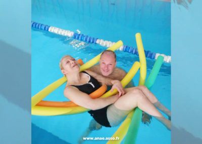 Séjour répit pour aidant et aidé avec Anaé vacances. Une personne en situation de handicap moteur se baigne à la piscine avec un accompagnateur.
