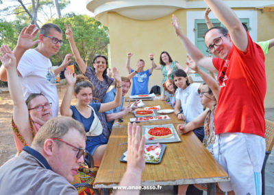 Séjour adapté handicap mental au centre de vacances Anaé de Hyères dans le Var. Un groupe de vacanciers va manger des tartes aux fraises qui ont été préparées lors d'un atelier pâtisserie.