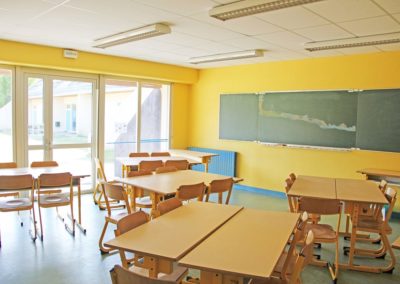 Centre de vacances Anaé La Rose des Vents à Piriac en Loire Atlantique. Une salle d'activités avec tableau et tables pour les séjours scolaires.