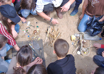 Des élèves trient des déchets sur la plage lors d'une classe découverte à la mer. Ils font un séjour scolaire au centre de vacances Anaé La Rose des Vents à Piriac en Loire Atlantique.