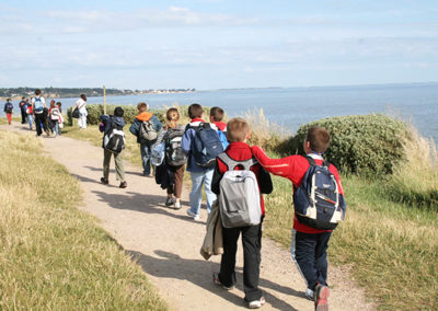 Des enfants en colonie de vacances se promènent le long de l'océan. Ils font un séjour au centre de vacances Anaé La Rose des Vents à Piriac en Loire Atlantique.