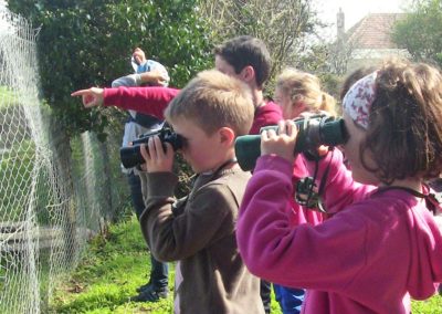 Des enfants en colonie de vacances font une activité pédagogique dans la forêt. Ils étudient la flore avec des jumelles. Ils séjournent au centre de vacances Anaé La Rose des Vents à Piriac en Loire Atlantique.