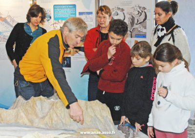 Un groupe d'élèves écoute un animateur lors d'un atelier pédagogique sur les glaciers à l'Espace Glacialis en Vanoise. Classe de neige avec Anaé Vacances.