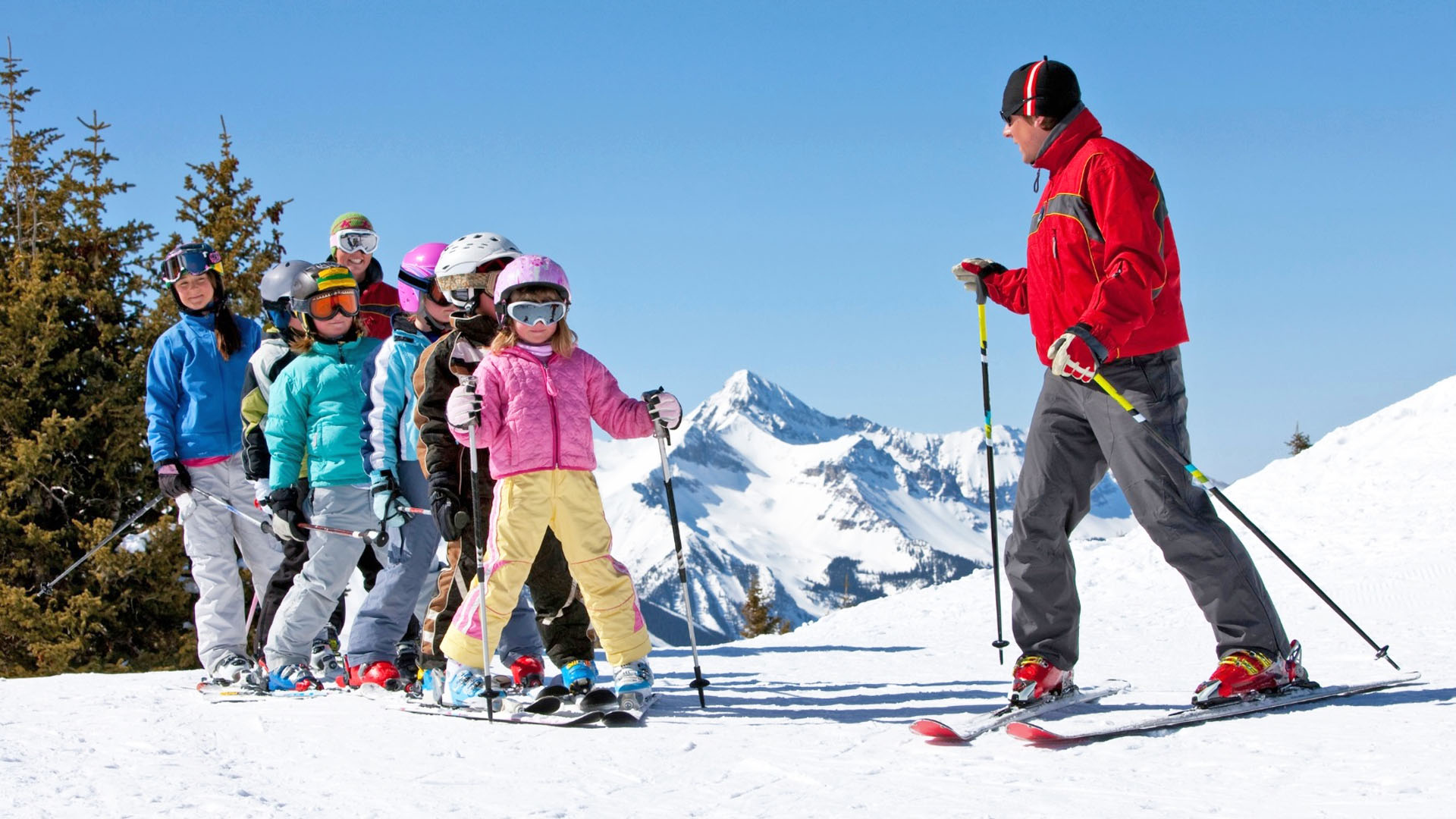 Classe de neige en Savoie avec Anaé Vacances. Un groupe d'élèves sur une piste de ski écoutent leur moniteur.