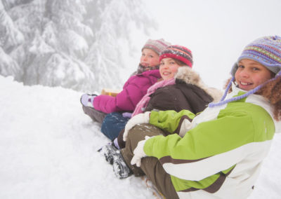 Des enfants font de la luge pendant une classe de neige en Savoie avec Anaé Vacances