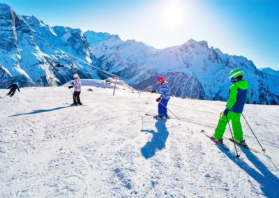 Des enfants apprennent à faire du ski avec leur moniteur pendant une classe de neige en Savoie avec Anaé Vacances.