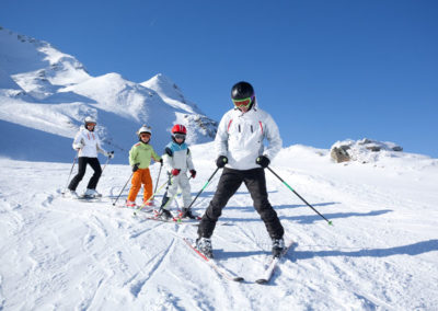 Des enfants apprennent à faire du ski avec leur moniteur pendant une classe de neige en Savoie avec Anaé Vacances.