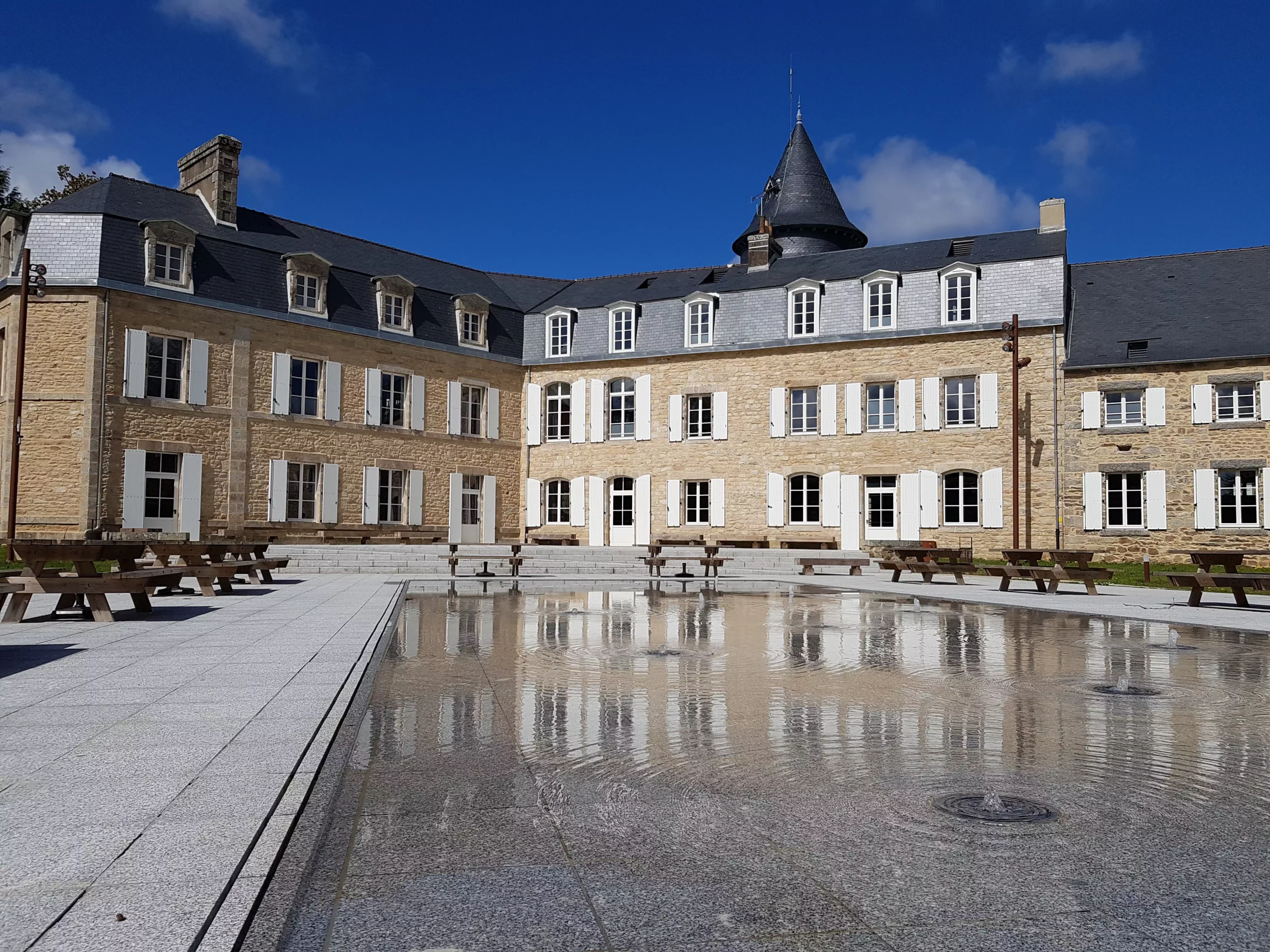 Photo du château avec son miroir d'eau du domaine de la Porte Neuve à Riec-sur-Bélon dans le Finistère en Bretagne